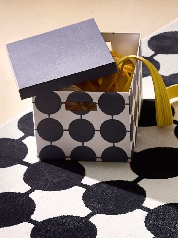 A white black/dotted TJENA storage box with lid