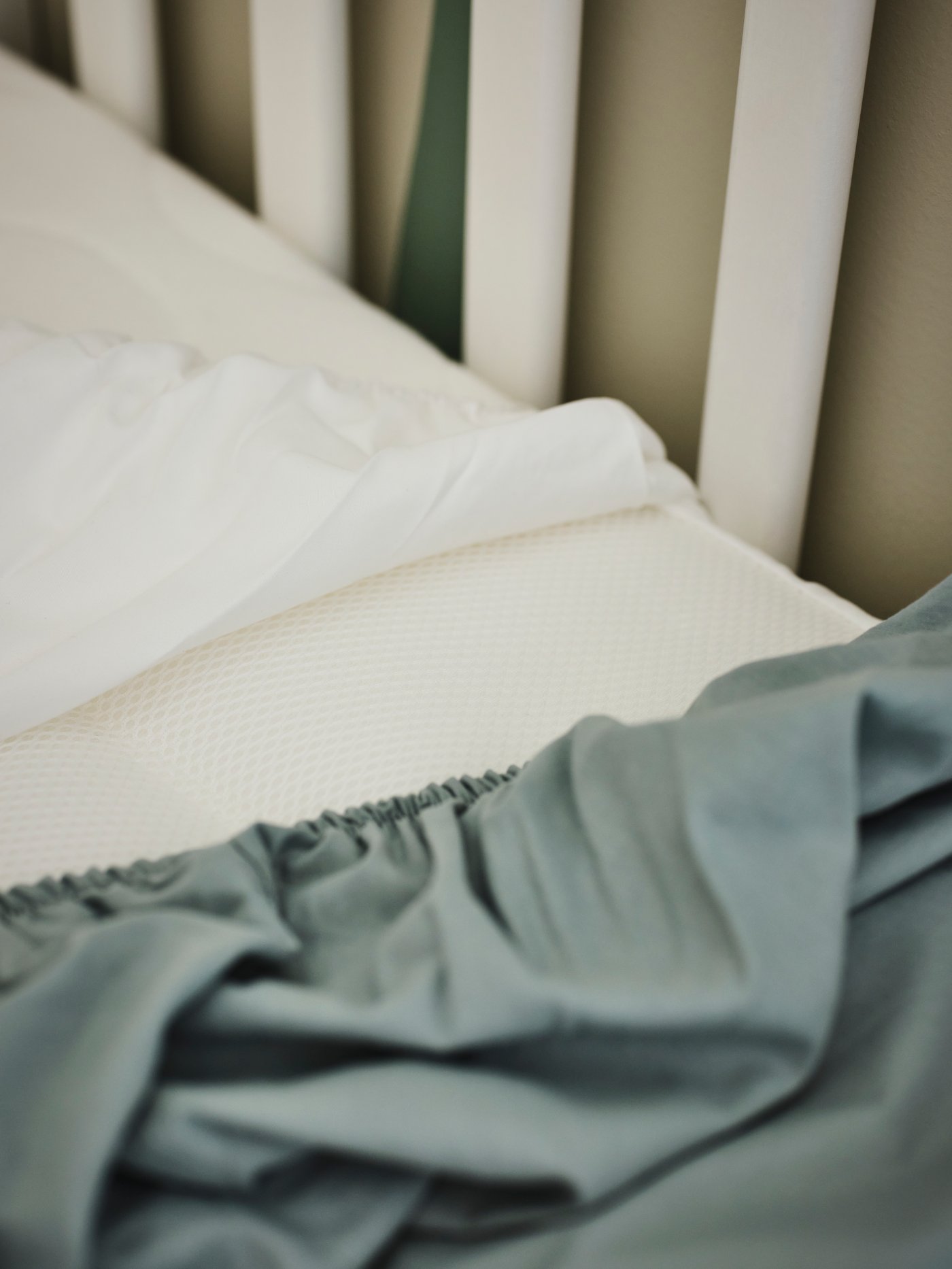 Detalle de ropa de cuna LEN en una cuna para bebés.