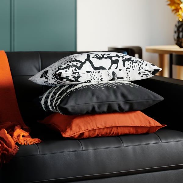 Tre kuddar ligger ovanpå en 3-sits soffa i läder och belagd textil i ett Instagramvänligt vardagsrum.