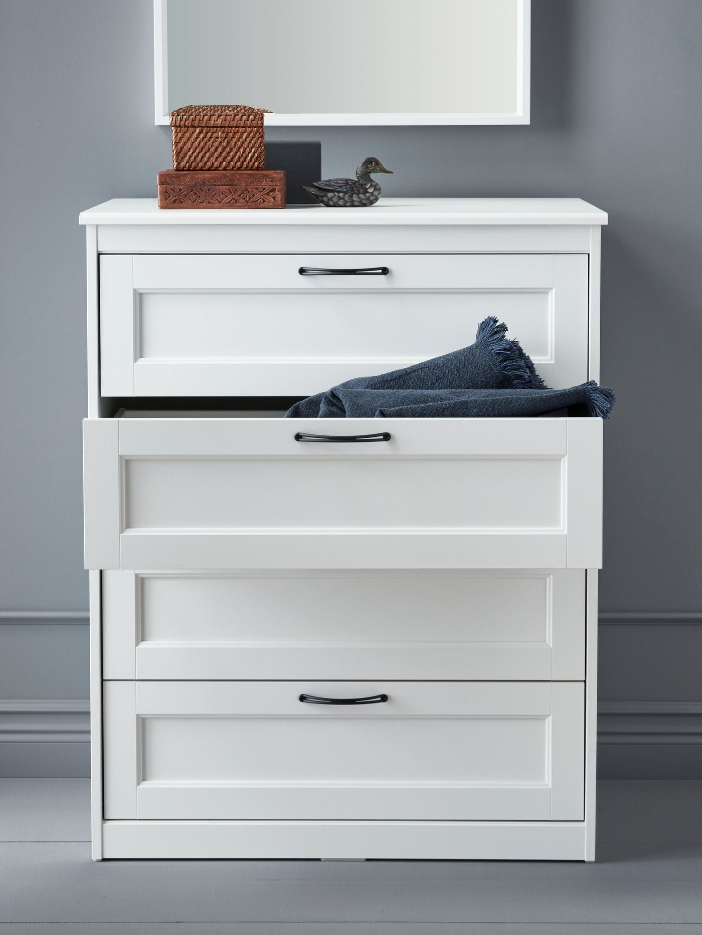 A white SONGESAND chest of 4 drawers in the bedroom