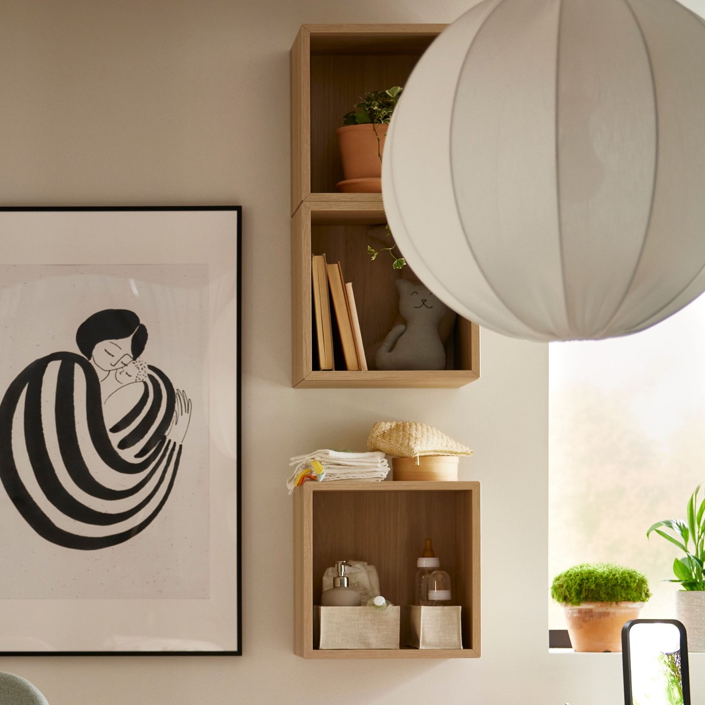 Tre EKET skabe med hvidbejdset egetræslook monteret på en væg bag en rund hvid REGNSKUR pendelskærm.