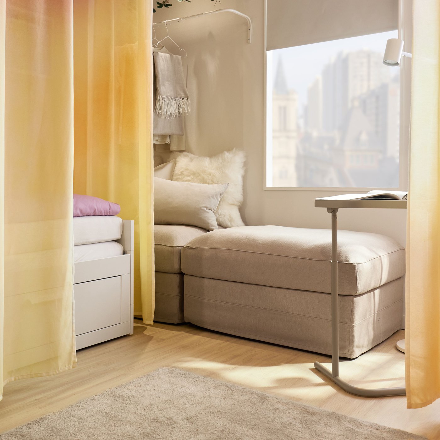 Two beige seaters under a window with a rack mounted on the wall to hang clothes. 