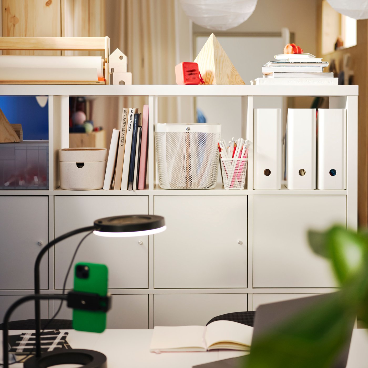 Living room with a KALLAX shelving unit used as a room divider, filled with storage, books and decorative objects.