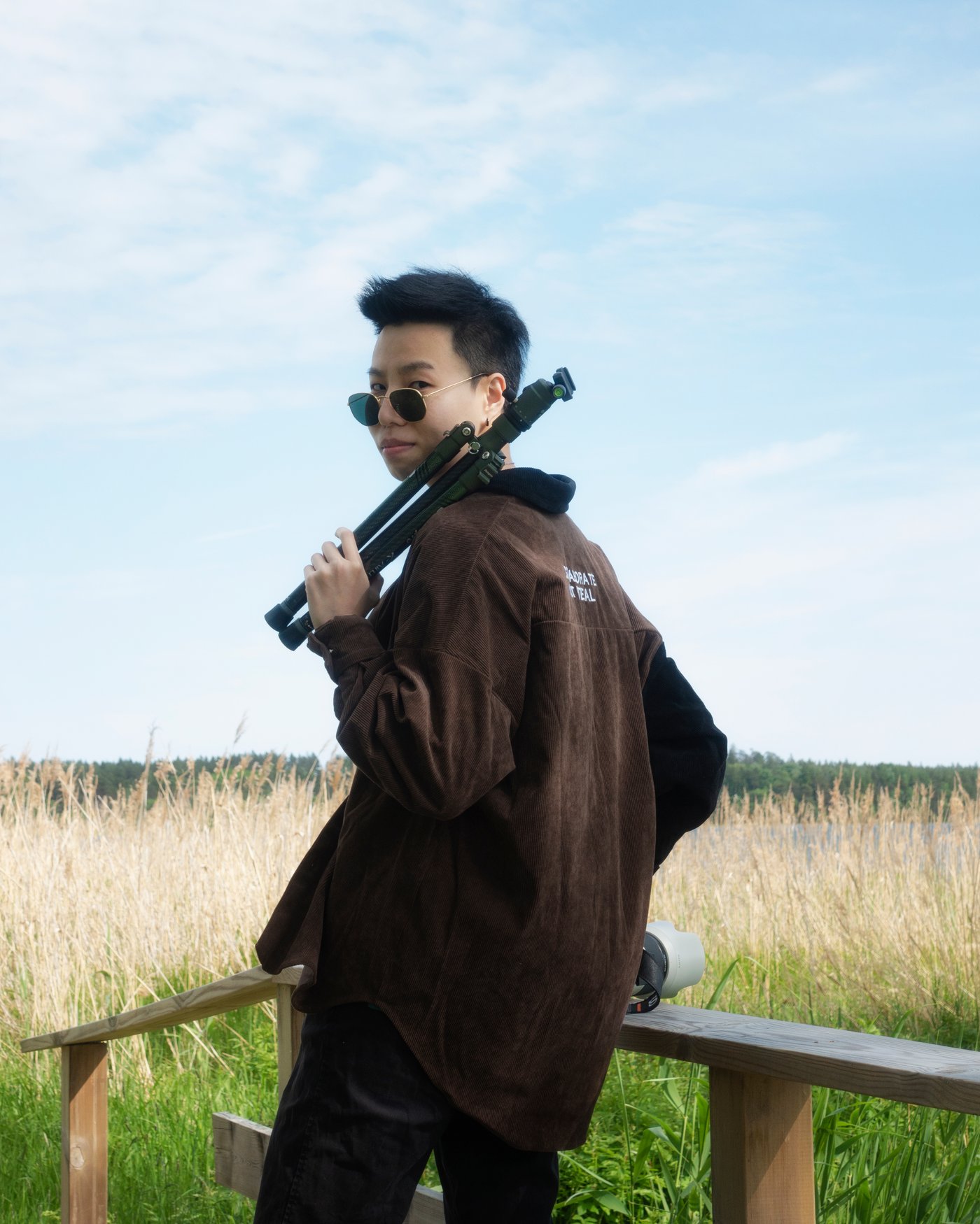 Photographer Lee holding a camera tripod and wearing sunglasses.