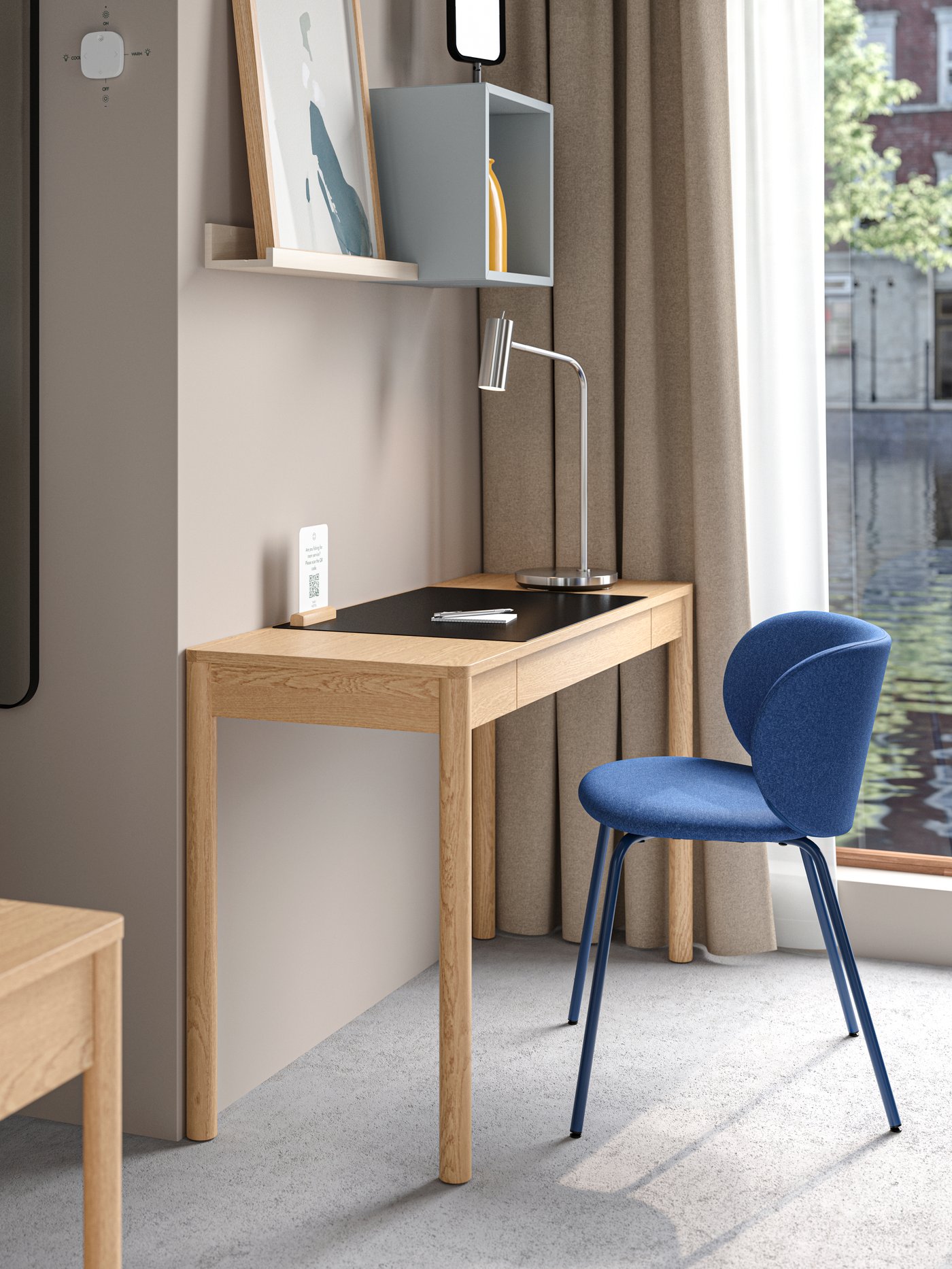 A TONSTAD desk in oak veneer and a blue KRYLBO chair in a houseboat hotel room with water outside the window.