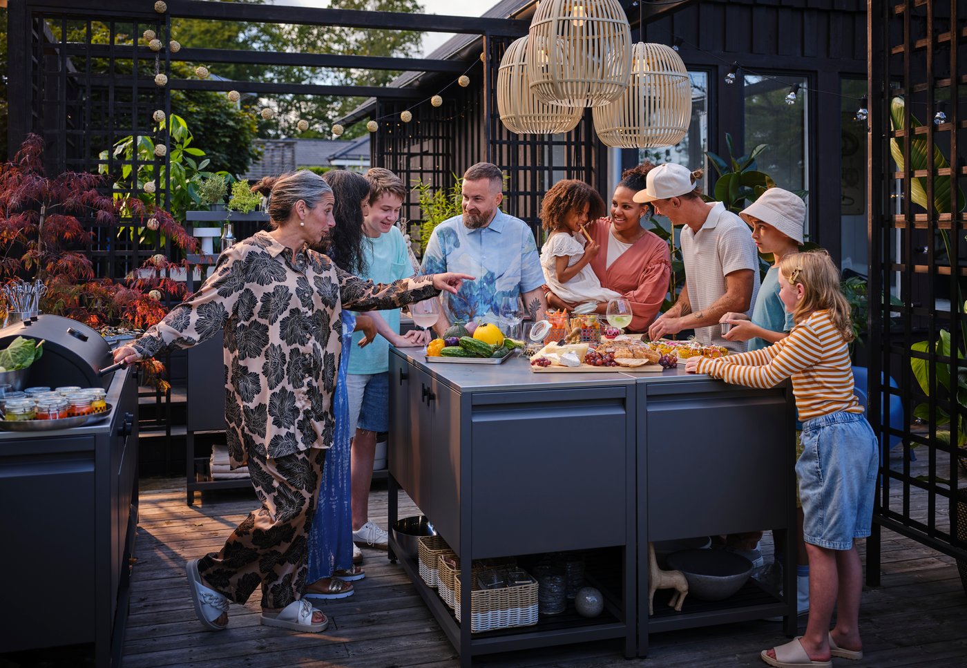 Perhe ja ystävät ovat kokoontuneet grillijuhliin terassille.