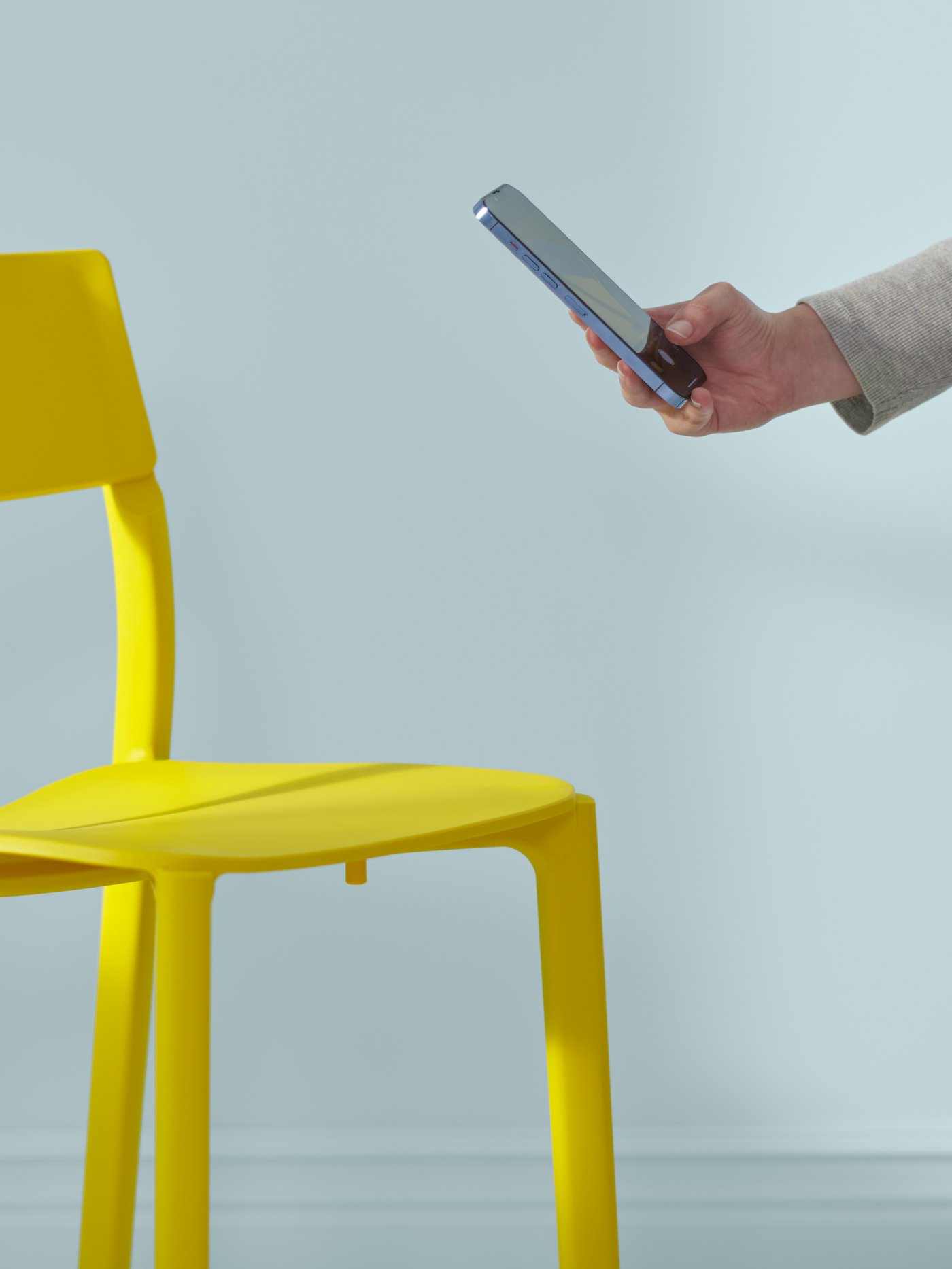 Person taking photograph of yellow IKEA chair