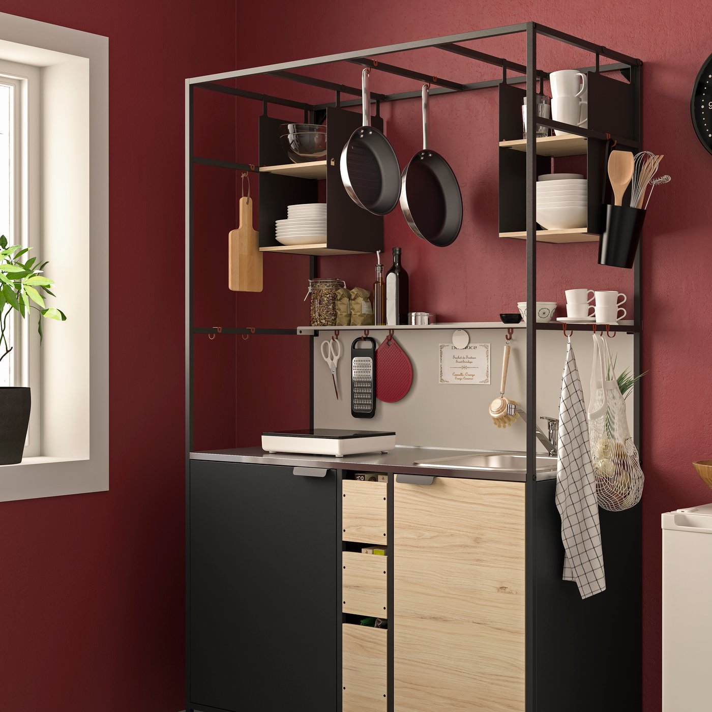 Musta/saarnipuun värinen ÄSPINGE-minikeittiö punaista taustaa vasten.