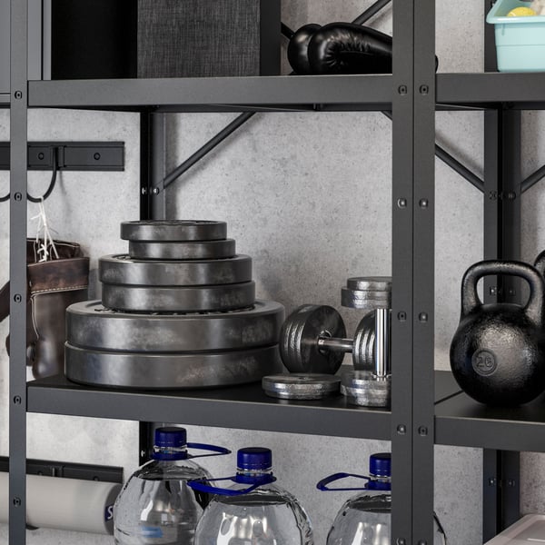 IKEA BROR black shelving units storing weight plates, dumbells and water bottles, and a black BROR rail with hooks holding boxing gloves. 