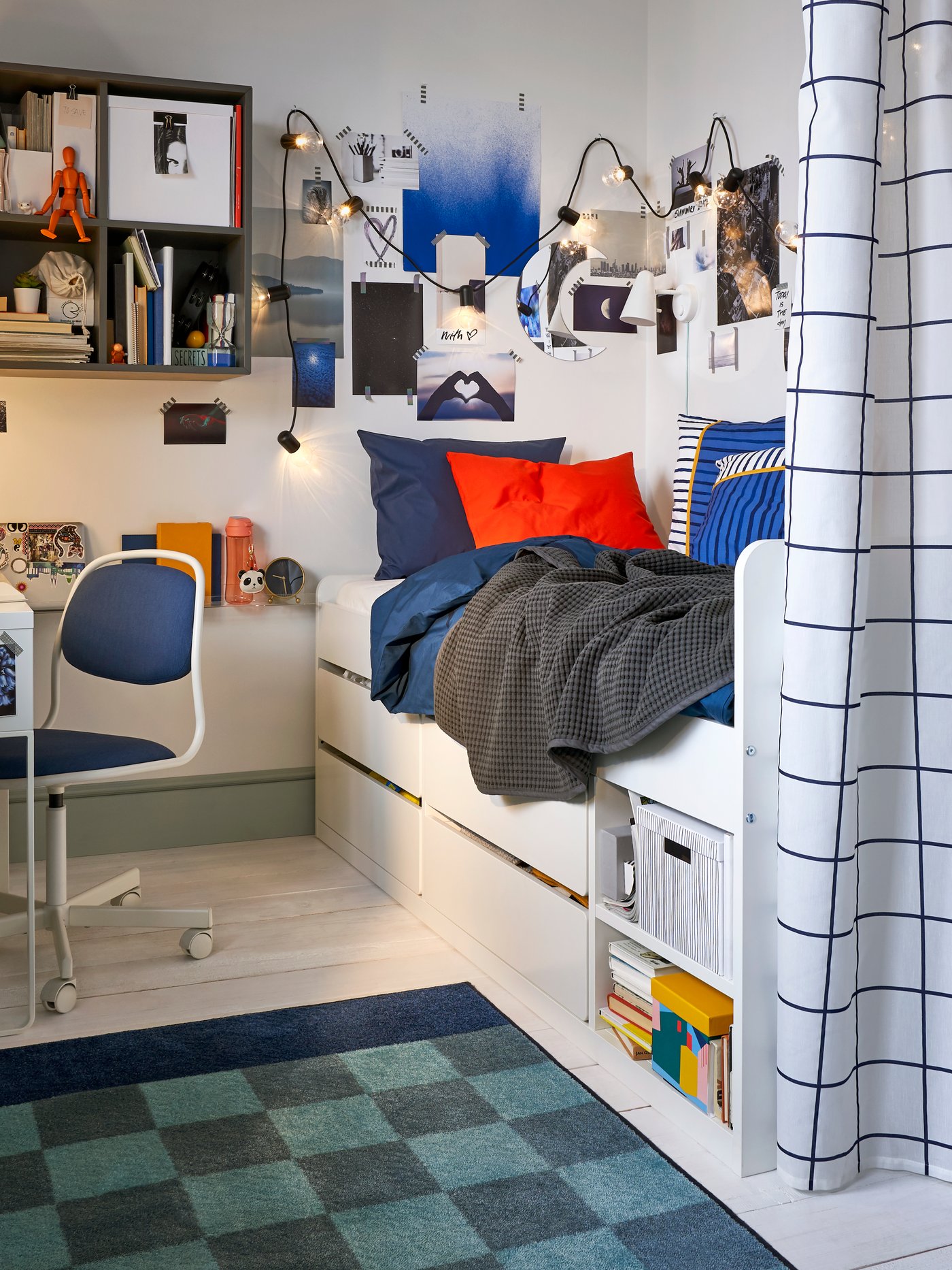 Dormitorio infantil con estructura de cama blanca con cajones y somier de pizarra, colcha de cuentas grises y edredón.