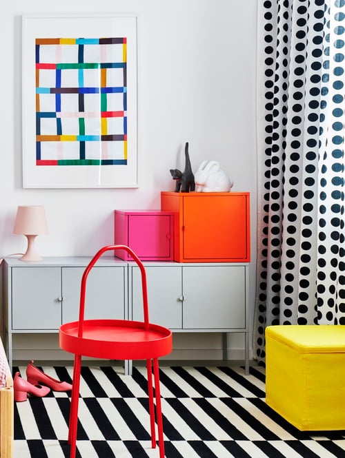 Schlafzimmer mit mehreren LIXHULT Schränken in unterschiedlichen Farben und Ausführungen, einem BOSNÄS Hocker mit Aufbewahrung und einem STOCKHOLM Teppich.