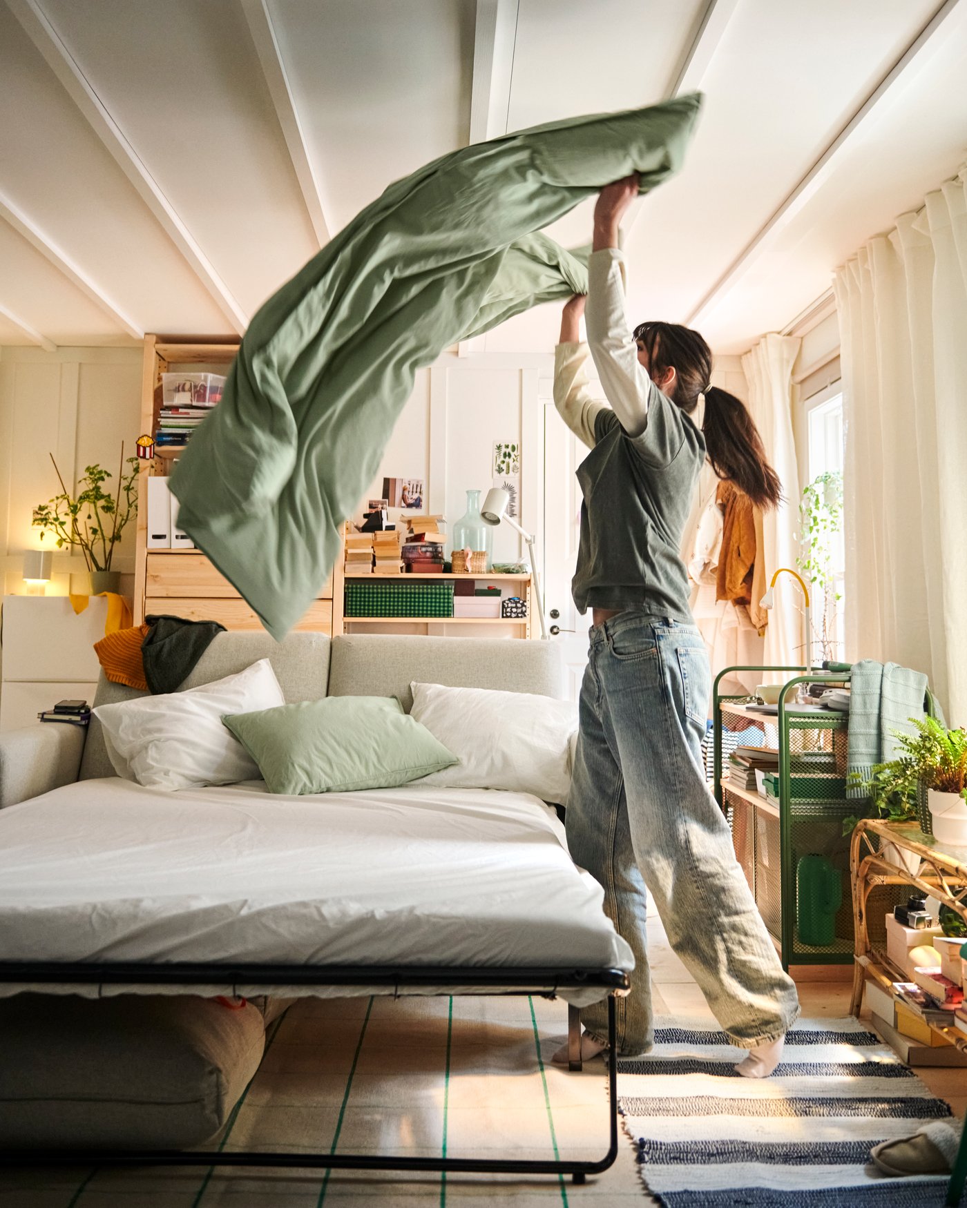 Un meuble NÅLMAKARE vert foncé/métal sur roulettes dans le salon