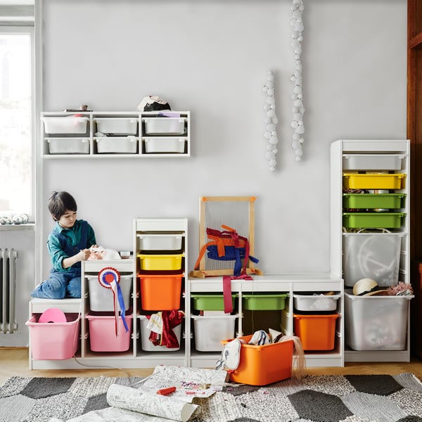 A green living room with large grey modular sofa and two kids playing.