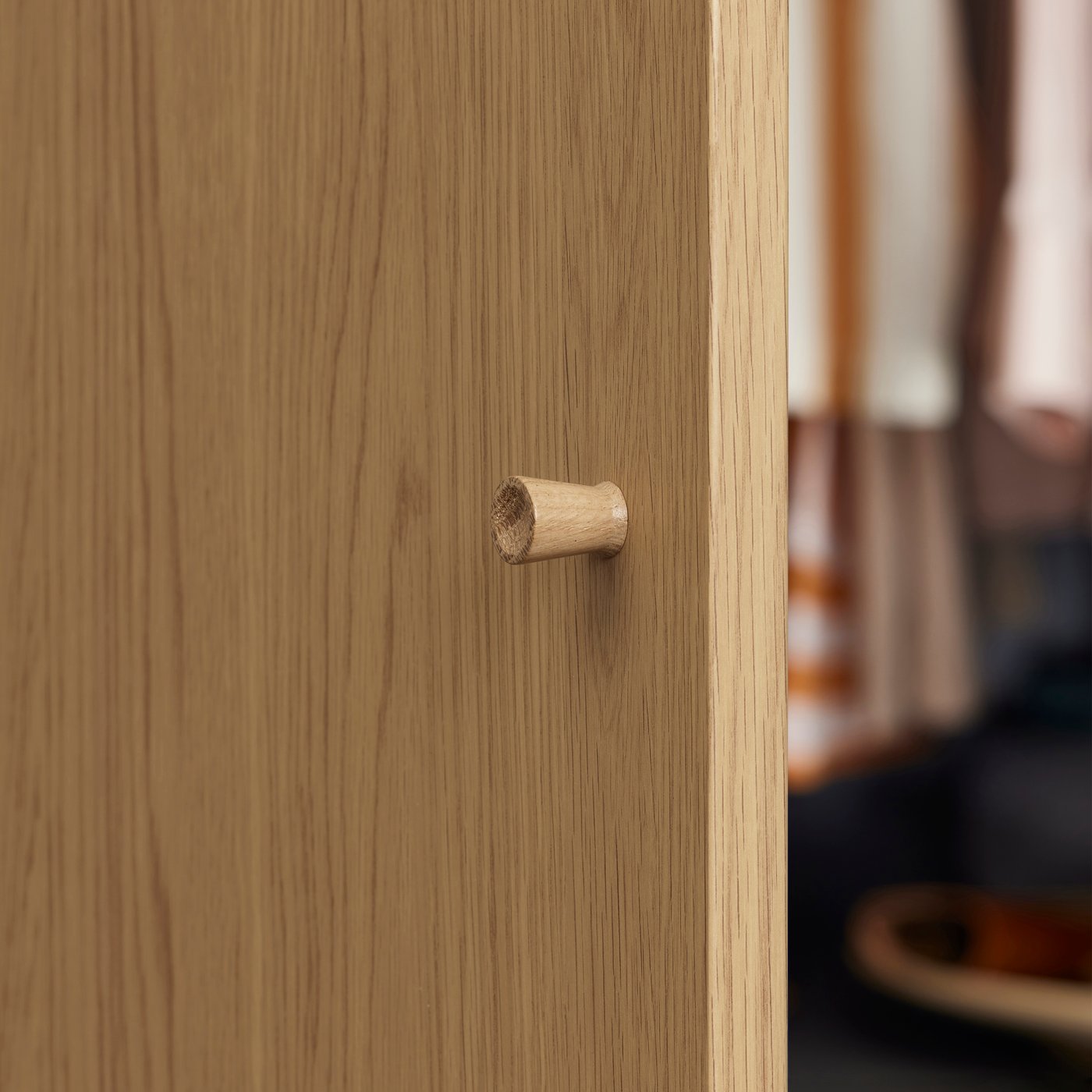 A close-up of a STORKLINTA oak effect door with a TÄRNESTAD knob made of oak.