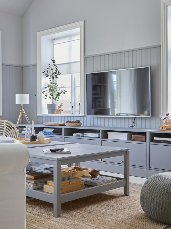 A living room where a grey HAVSTA TV bench with plinth and two grey HAVSTA coffee tables create a coordinated style together.