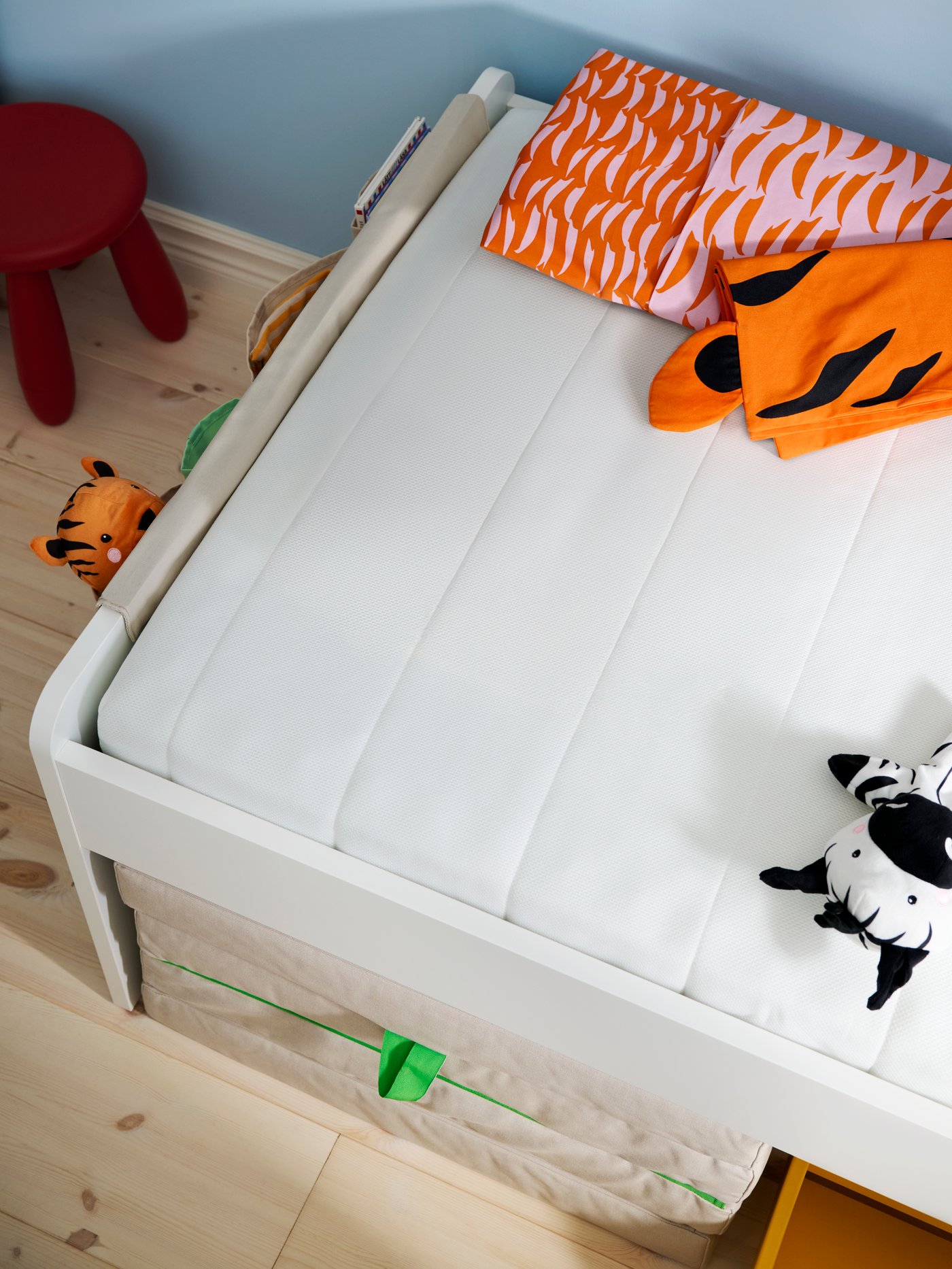 Close-up taken from above a children’s bed with ÅFJÄLL mattress and SOTNÄTFJÄRIL mattress protector.