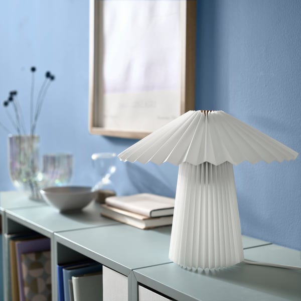 A pleated white KUDDLAVA table lamp