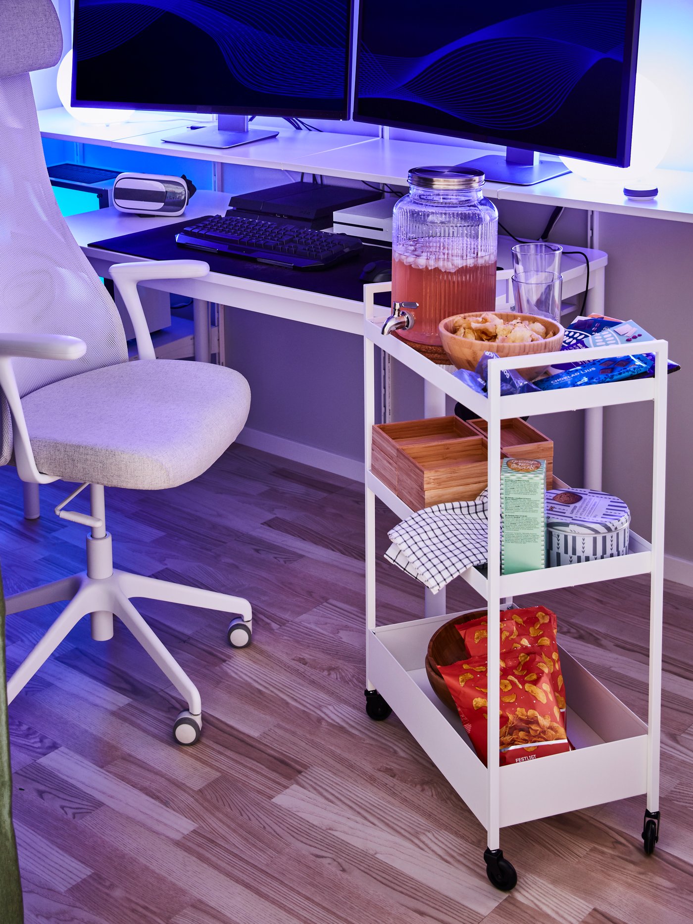Workspace with simple white trolley made out of steel supporting a jar with tap, next to a beige office chair with armrests.