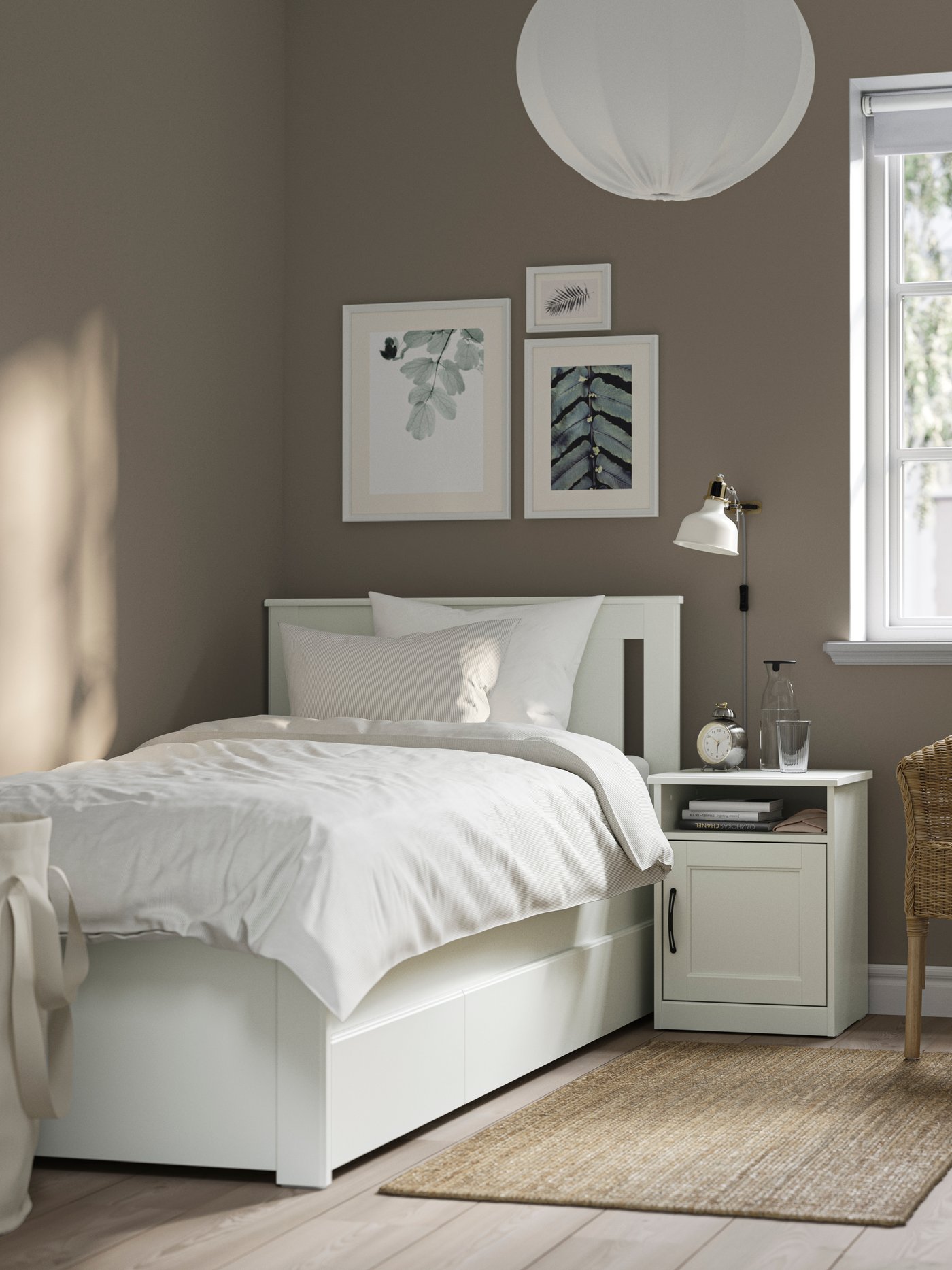 A white SONGESAND bed frame with 2 storage boxes in the bedroom