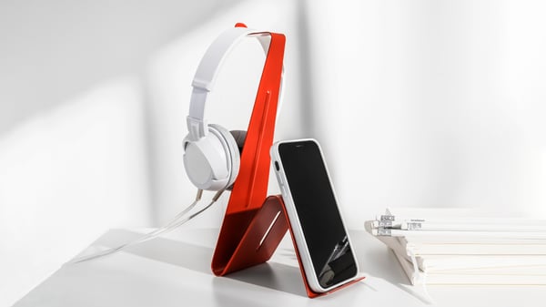A red MÖJLIGHET headset/tablet stand
