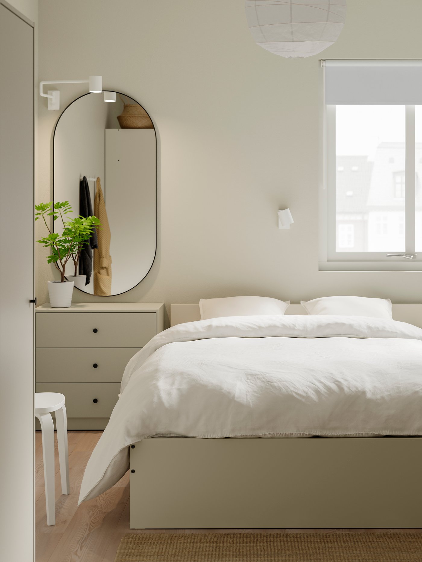 Dormitorio moderno con una estructura de cama beige y un cabecero de madera, junto a una cómoda de 3 cajones y un espejo.