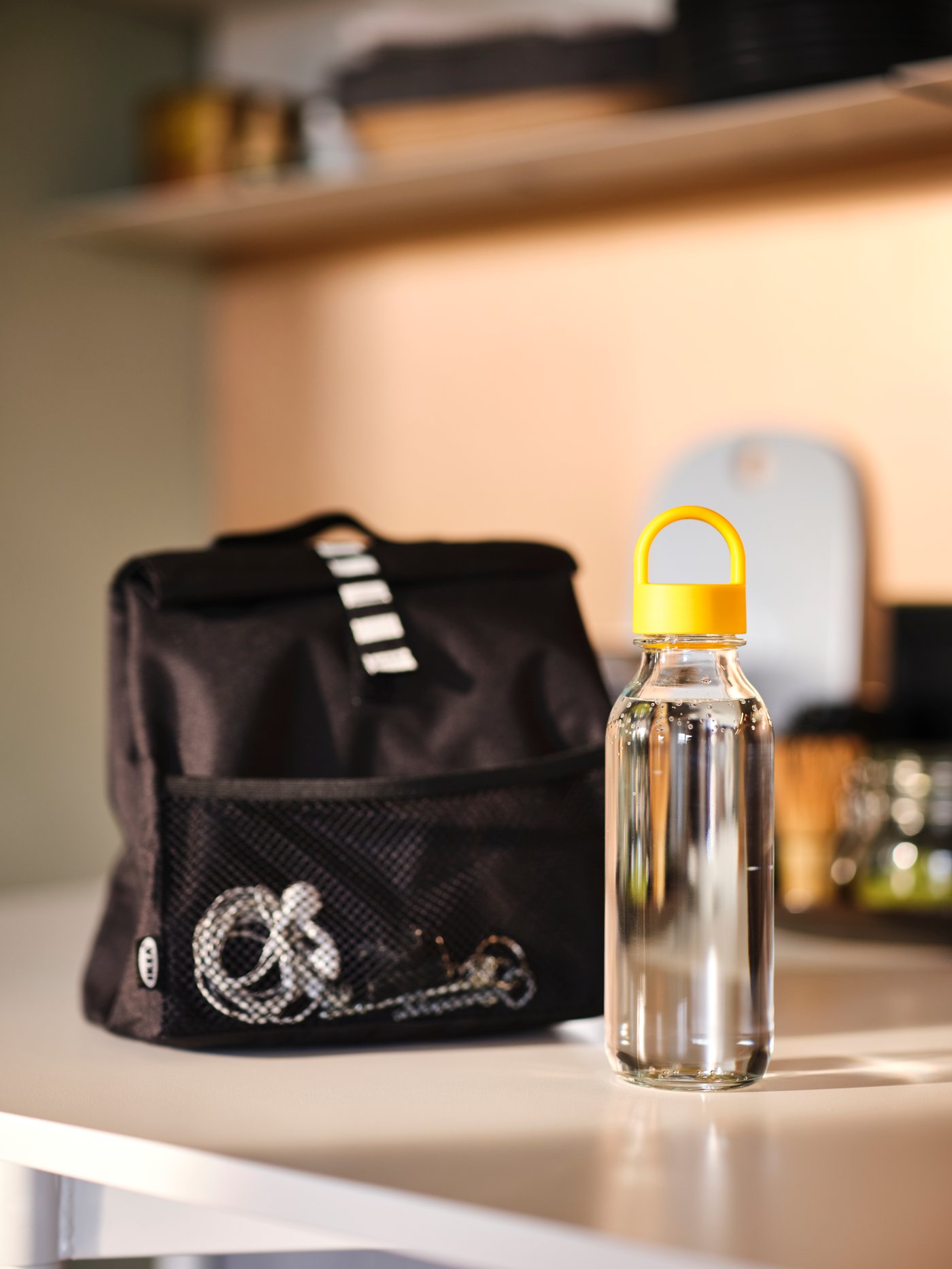 A black lunch bag and a water bottle are on the counter.