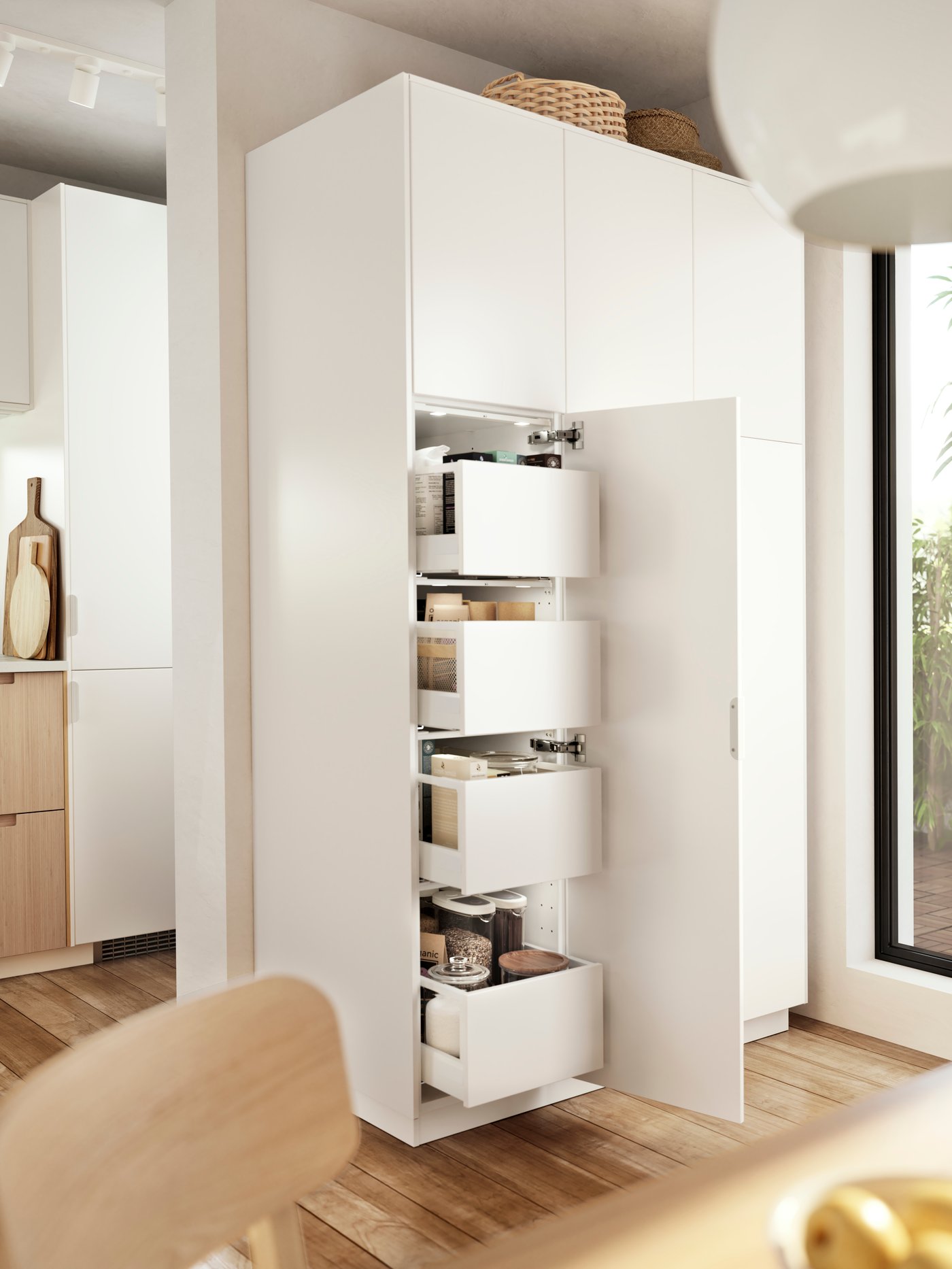 A white VEDDINGE kitchen cabinet with the door opened and drawers showing.
