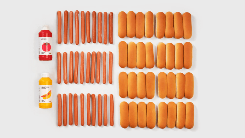 Hot-dogs avec pains et deux bouteilles de sauce, rangés sur fond blanc, présentation alimentaire minimaliste