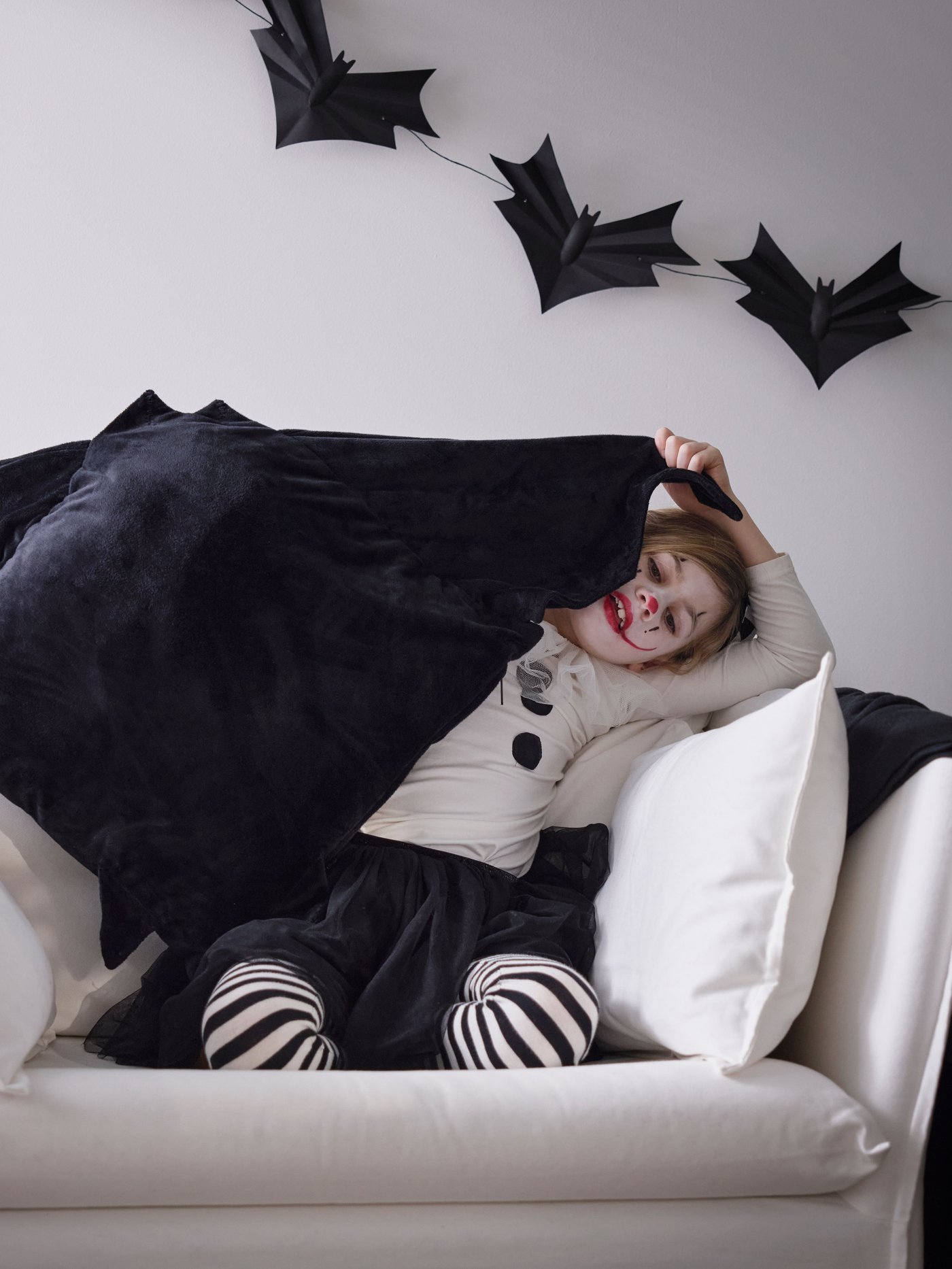 A bat black HÖSTAGILLE cushion cover in the living room