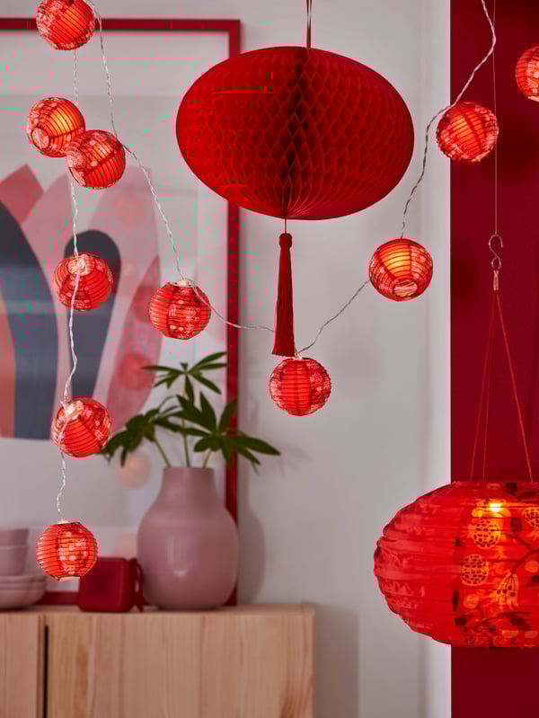 A pomegranate/red FÖSSTA LED lighting chain with 12 lights