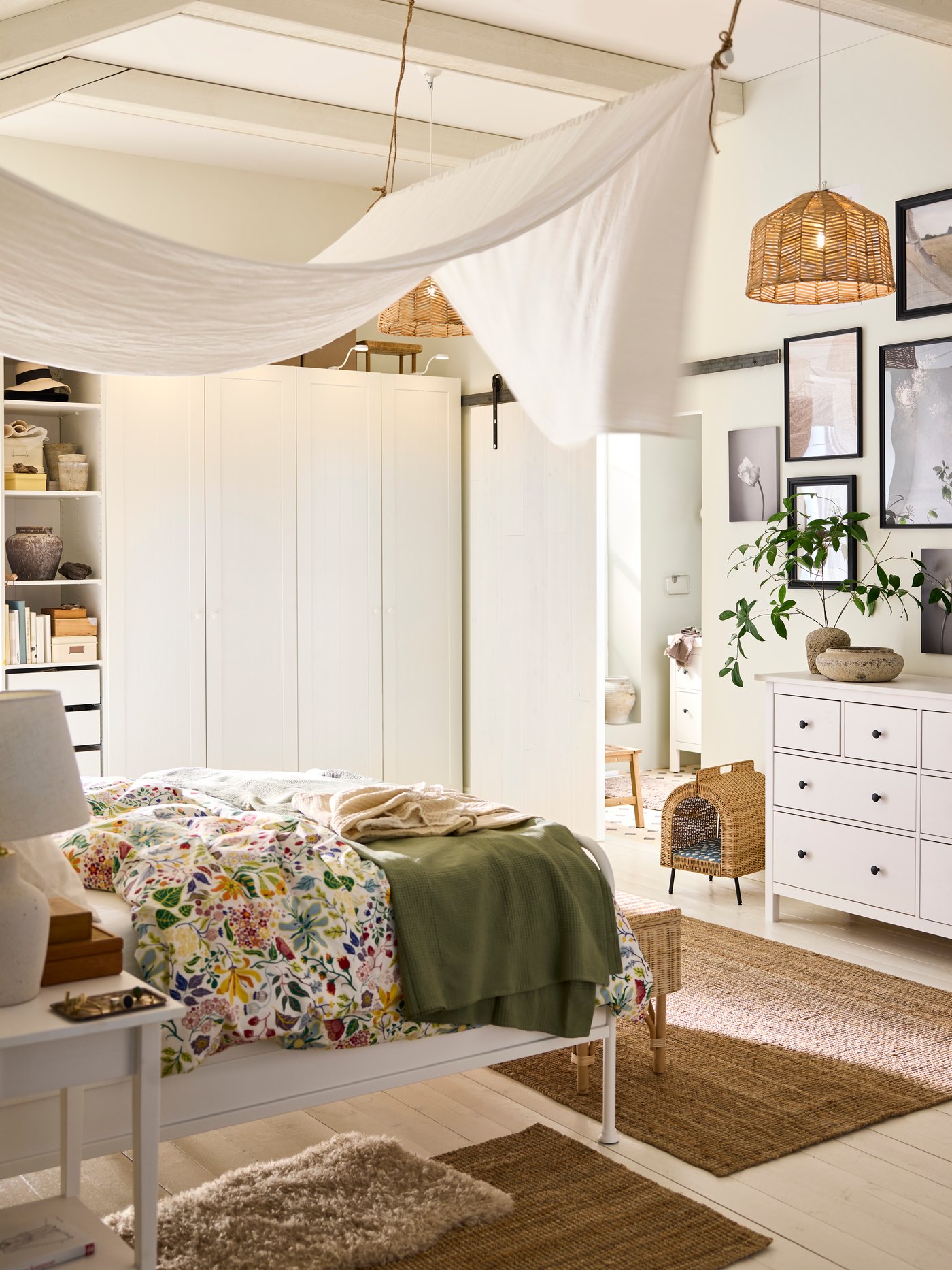 En seng redt op med STRANDLUMMER sengetøj og et grønt sengetæppe foran et PAX/GULLABERG garderobeskab i et soveværelse med dæmpet belysning.