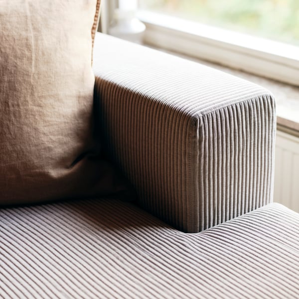 Dettaglio di un elemento chaise-longue JÄTTEBO con fodera grigio-beige.