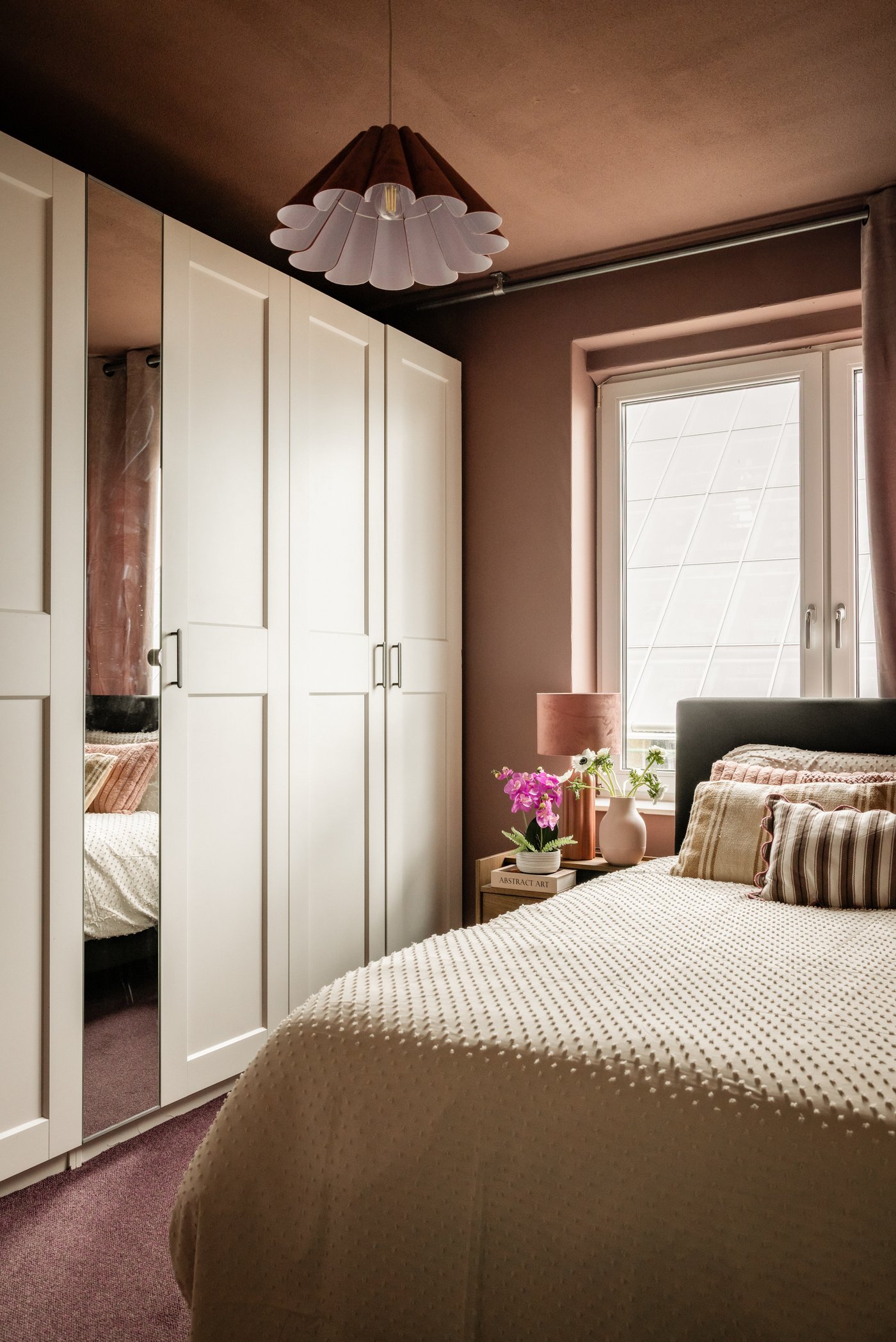 Slaapkamer met tegen de muur een grote, beige PAX kledingkast met spiegel. 