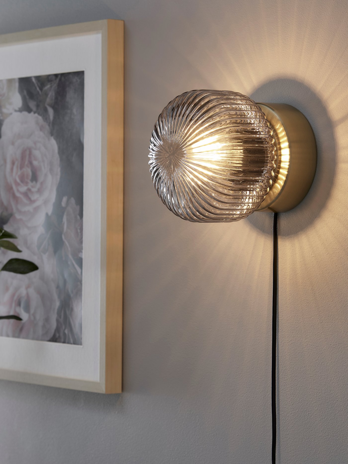 A brass/grey clear glass SOLKLINT wall lamp