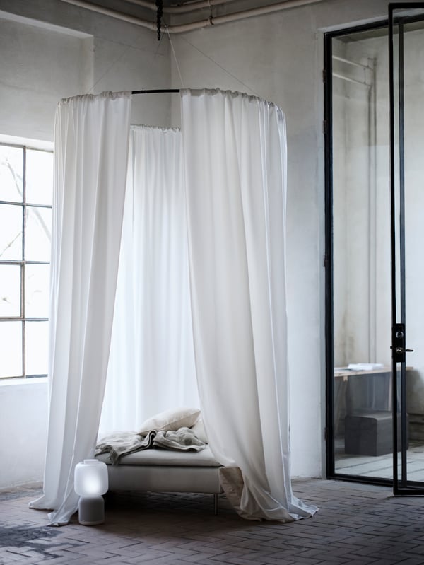 GUNNLAUG noise-absorbing curtain surrounding a bed in the middle of a bedroom