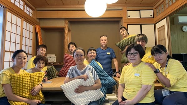 和室でクッションを抱えてポーズをとる人たち