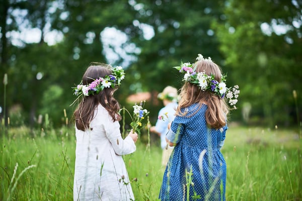 Twee meisjes in een veld met bloemenkronen op hun hoofd