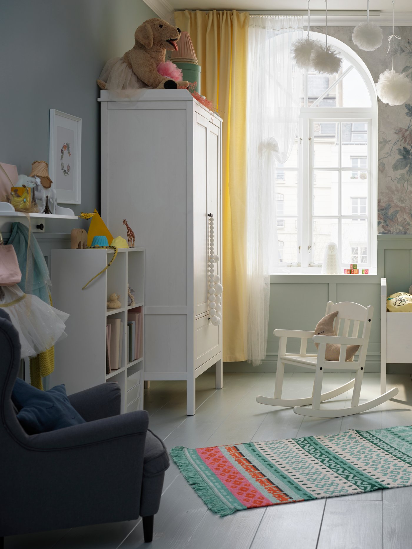 Dormitorio moderno con armario blanco, alfombra tejida lisa, un par de cortinas y una estantería de pared.