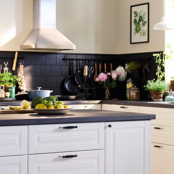 Ett stort kök i traditionell stil med vita BODBYN‑fronter, en köksö och en matgrupp i mörkt trä.