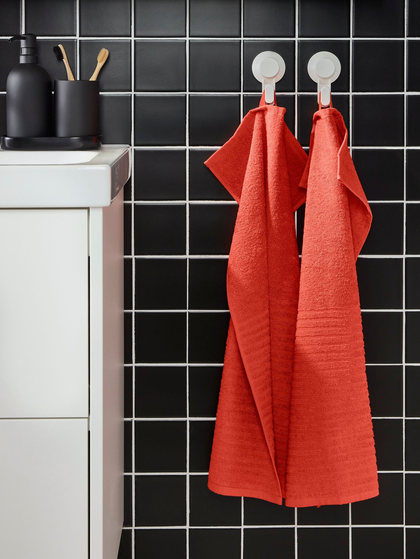 An orange-red VÅGSJÖN hand towel in the bathroom