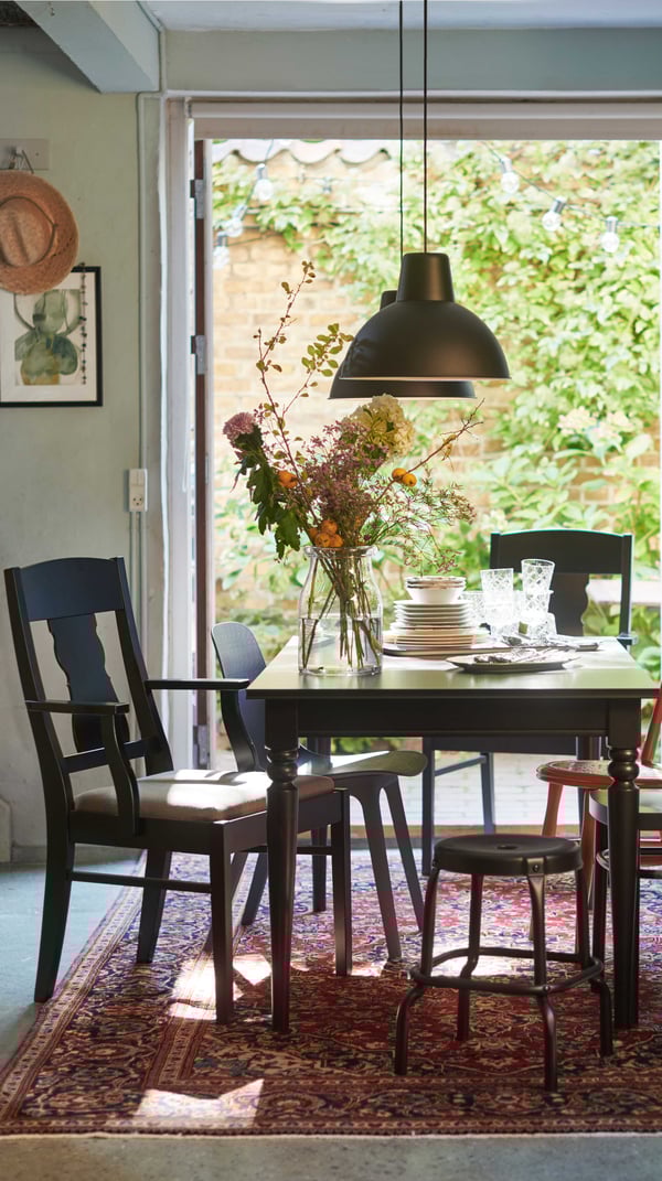 A black/Nolhaga grey-beige INGATORP chair with armrests in the dining room