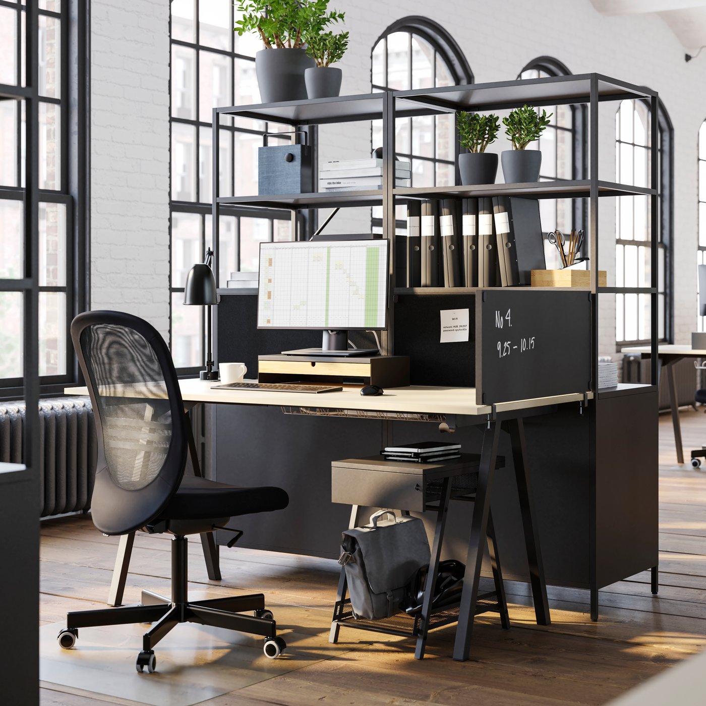 An office featuring a dark grey TROTTEN desk with a black office chair, a TROTTEN drawer unit, and a desk screen.