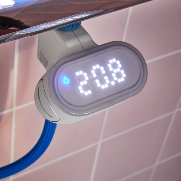 A BERGVATTNET water meter for shower is connected to a thermostatic shower mixer and a blue hose in a tiled shower.