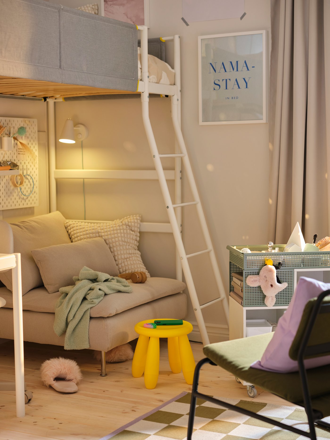 Un módulo de 1 plaza SÖDERHAMN junto a un carrito gris, un taburete infantil amarillo y un sillón en una habitación infantil.
