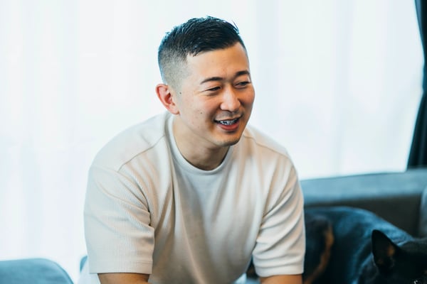 笑みを浮かべて話す男性。
