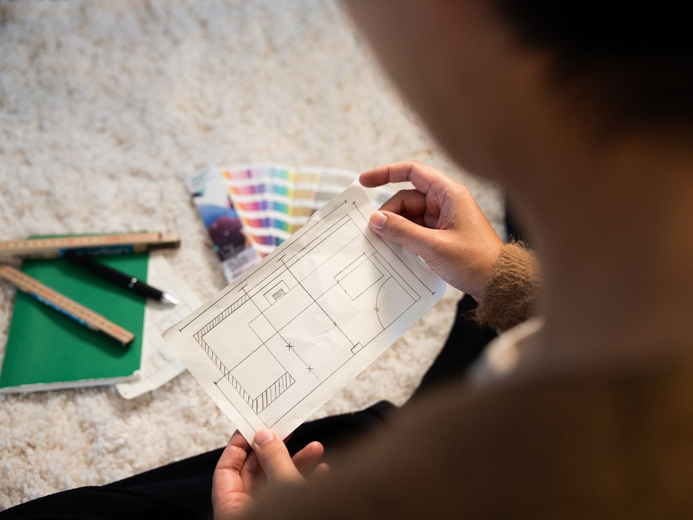 Une personne tenant un croquis de plan entre les mains