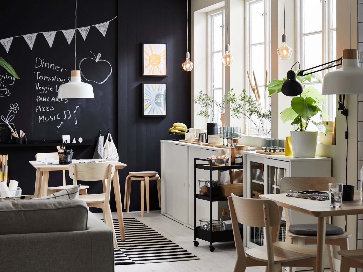 A dining room with three big windows and a blackboard wall has two LISABO tables in ash veneer with matching chairs.