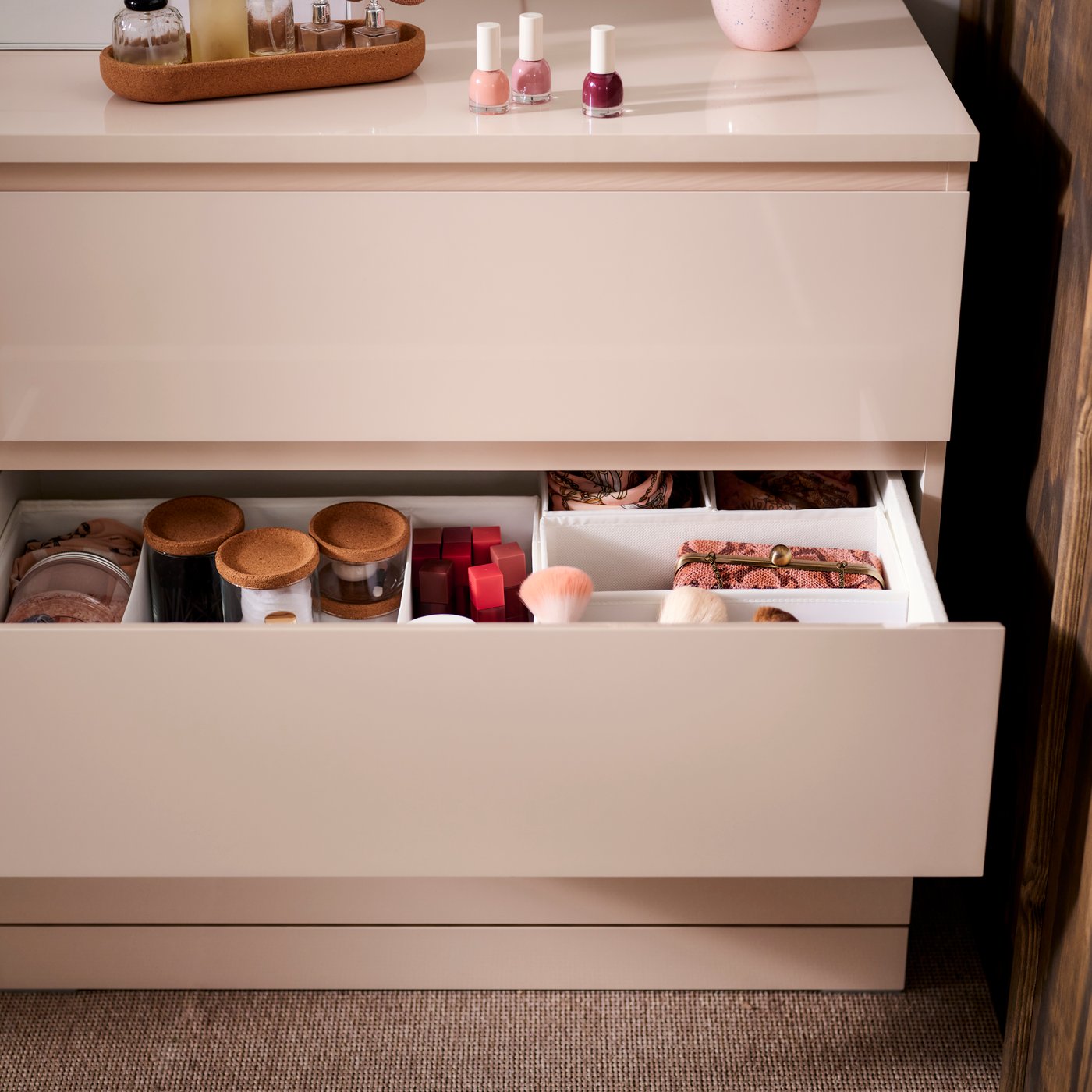 Dreischubladige MALM-Kommode mit rundem Spiegel und vertikalen Leuchten an der Wand. Auf der Kommode stehen Pflanzen, Dekoration und ein gerahmtes Bild. Die Szene zeigt ein stilvoll eingerichtetes Schlafzimmer mit modernen Akzenten.