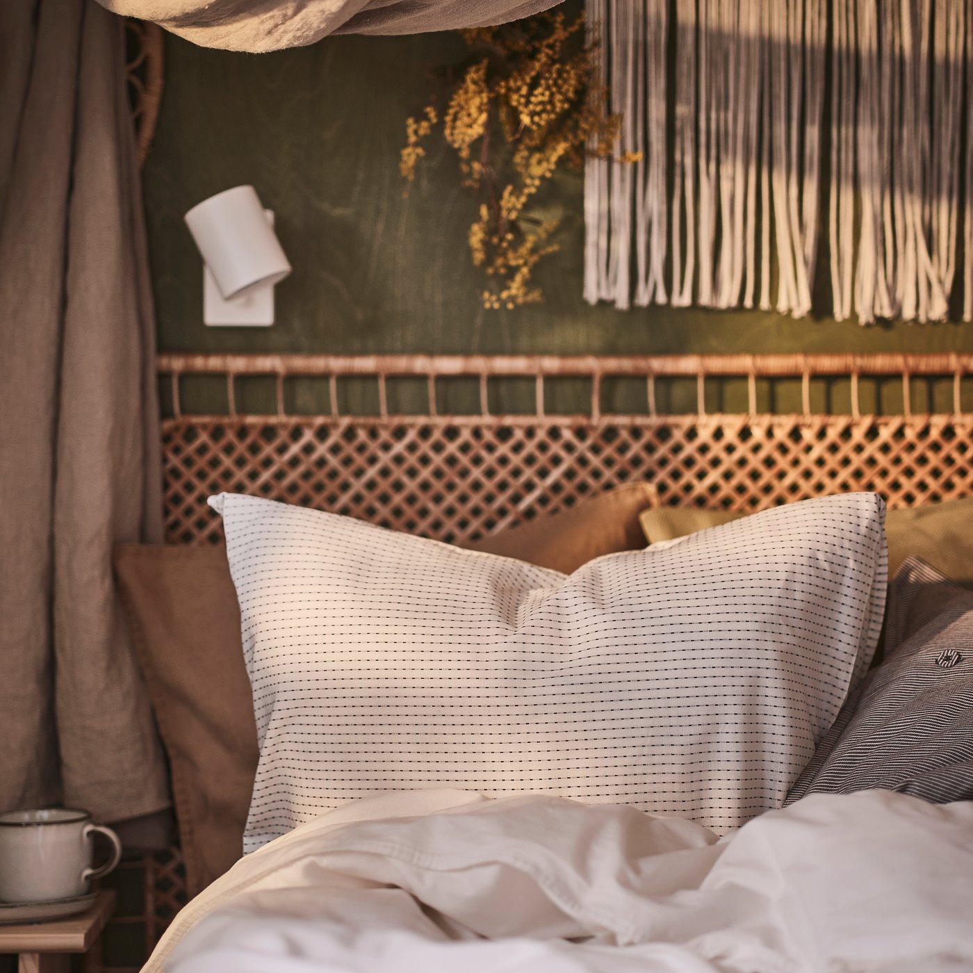 Een handgemaakt rotan TOLKNING hoofdbord in een bohemian slaapkamer.