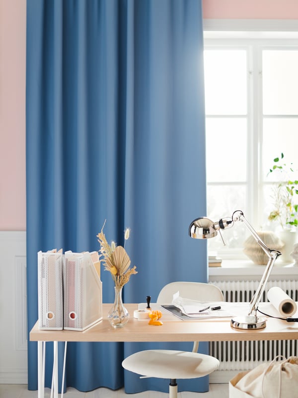 A clear glass VILJESTARK vase in the home office